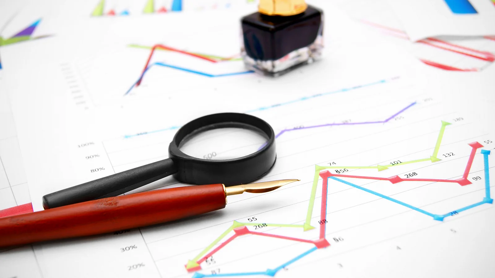Marketing research – a magnifying glass and charts presenting the analysis of data